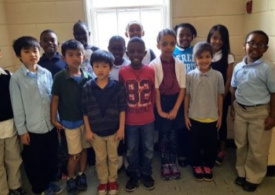 A group of children standing in front of a window.