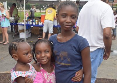 Three young girls posing for a picture at an event.