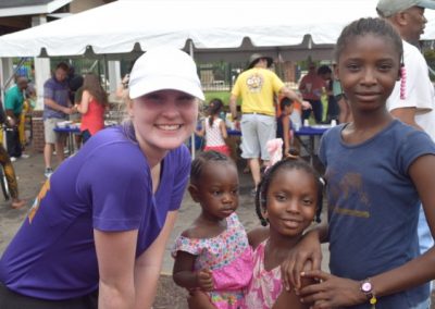 A woman standing next to two children.