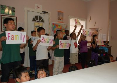 A group of children holding up signs in front of their faces.