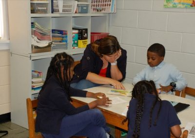 A group of children sitting at a table reading books.