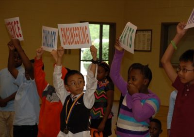 Two children holding up signs in a room.