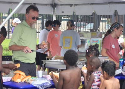 A group of people eating food at an outdoor event.