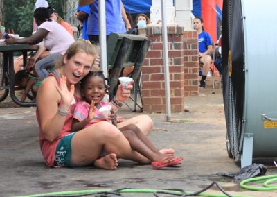 A woman and girl sitting on the ground.