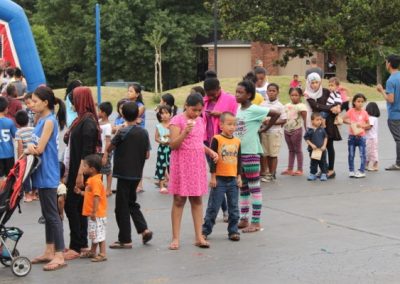 A group of people standing around in the street.