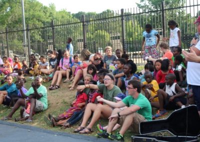 A group of people sitting on the grass.