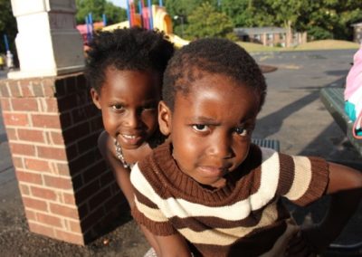 Two young children are posing for a picture.