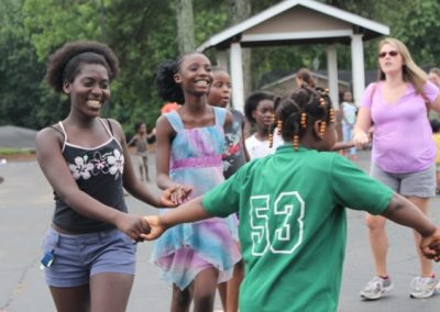 A group of young people holding hands and dancing.