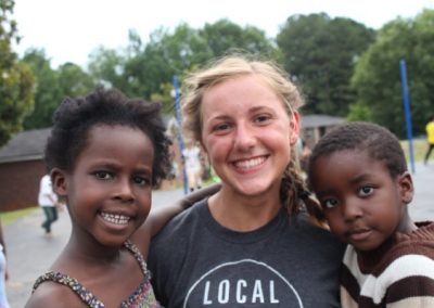 A woman smiles with two other women.