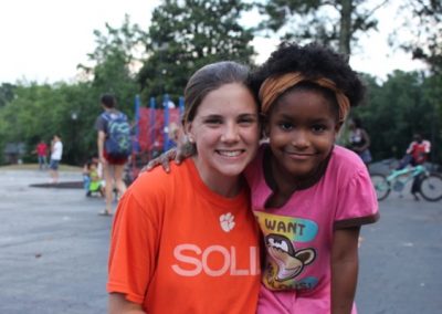 Two girls are posing for a picture together.