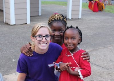 A woman and two girls posing for the camera.