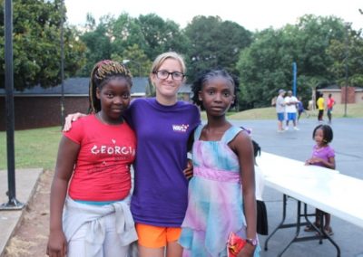 Three girls posing for a picture with their teacher.