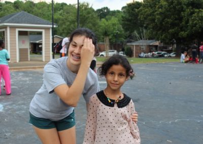 Two girls posing for a picture in the street.