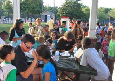 A group of people sitting at tables eating food.