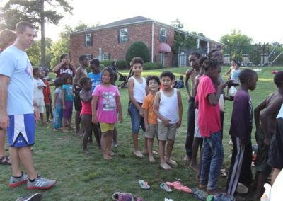 A group of children standing in the grass.