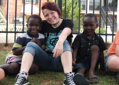 A woman sitting on the ground with two children.