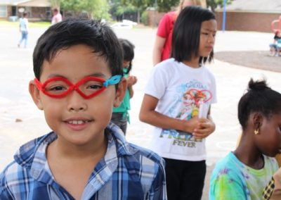 A group of children wearing glasses and smiling.