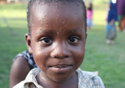 A young boy with brown eyes and a white shirt.