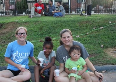 A group of people sitting on the grass.